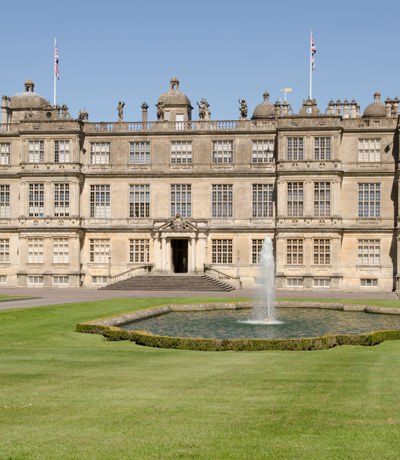 Grand Longleat House in Wiltshire, with symmetrical gardens and fountain in front, Near Brokerswood Holiday Park.