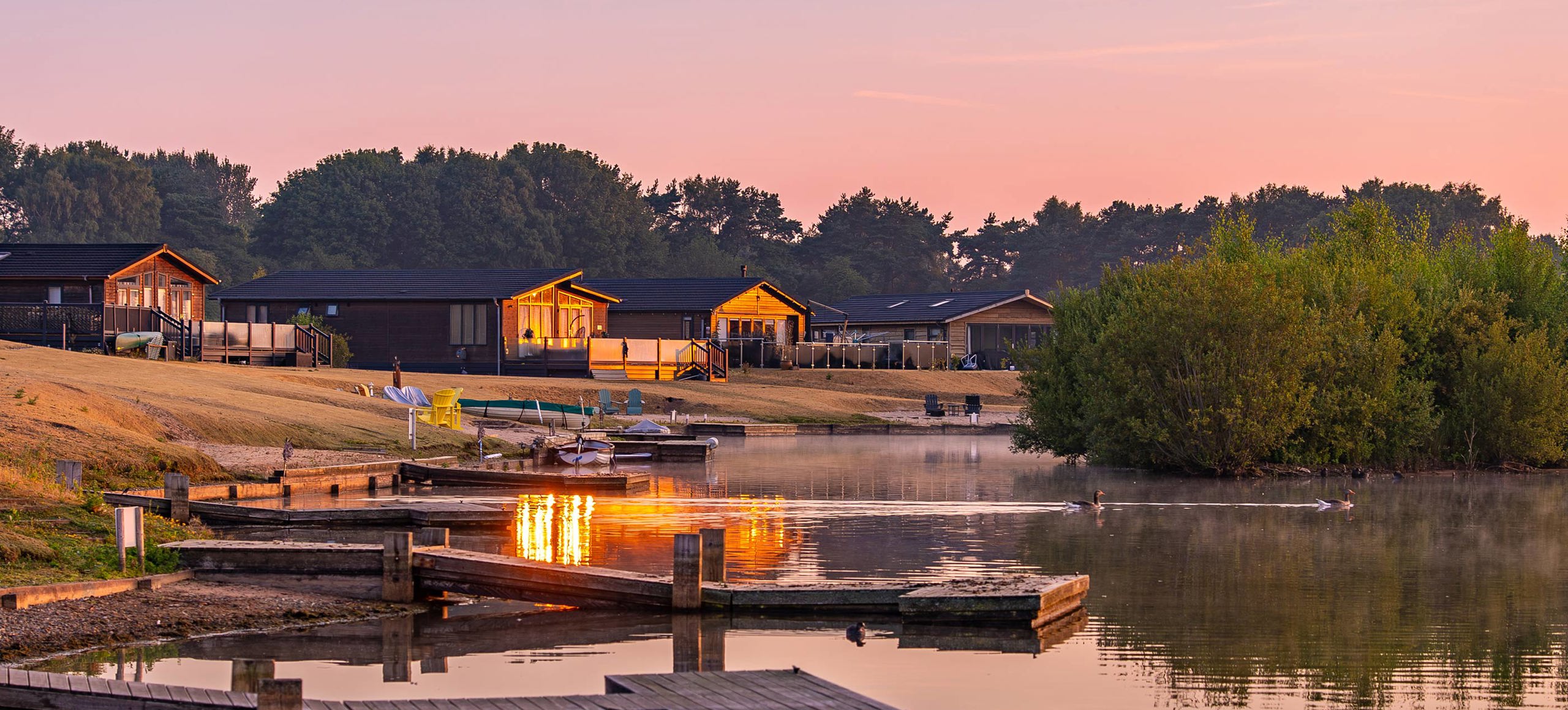 Delamere Lodges And Lake At Sunrise