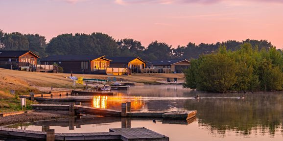 Delamere Lodges And Lake At Sunrise
