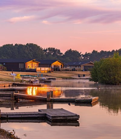 Delamere Lodges And Lake At Sunrise