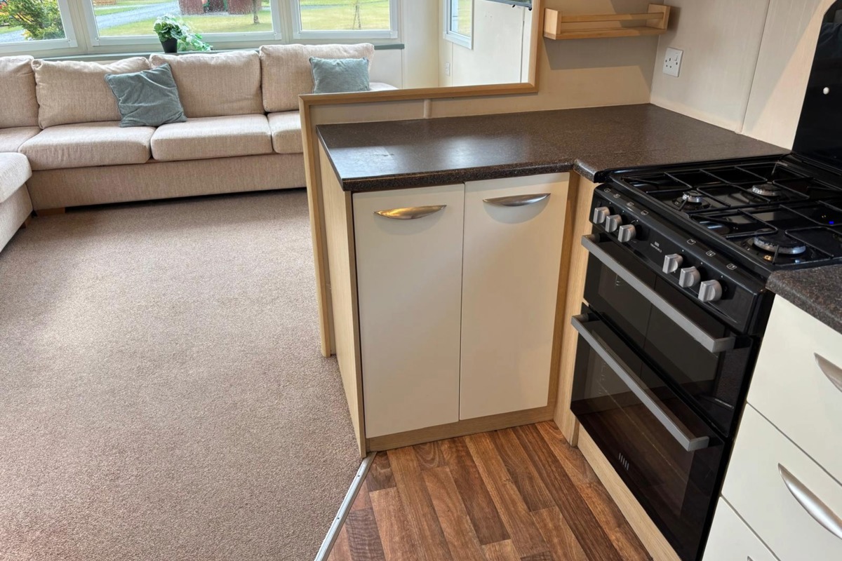 Carnaby Casablanca, cooker in kitchen and sofa in living area at Dartmoor View