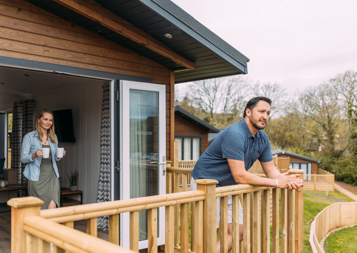 Devon Hills Couple On Decking With Drink Looking At View