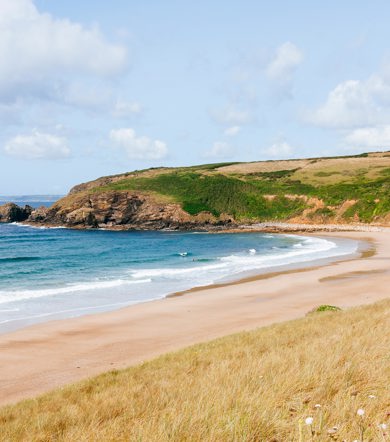 Golden sandy shoreline of Praa Sands beach with blue sea near Praa Sand Holiday Park