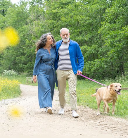 Couple walking their dog in nature