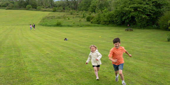 Devon Hills Family Running In The Field