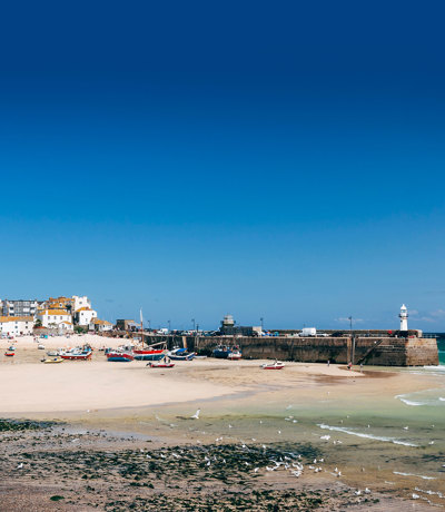 St Ives harbour and beach with boats resting on the sand at low tide near Praa Sand Holiday Park.
