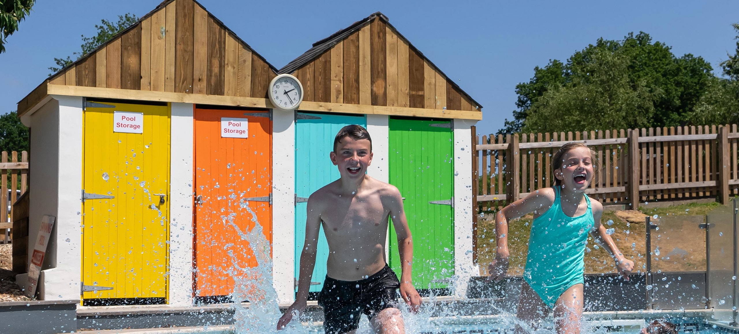 Young boy and girl running in outside Finlake pool