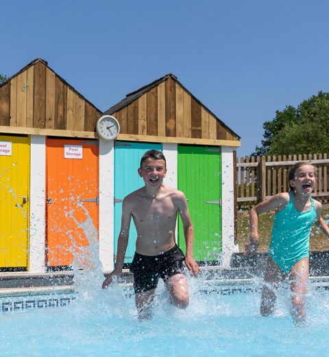 Young boy and girl running in outside Finlake pool