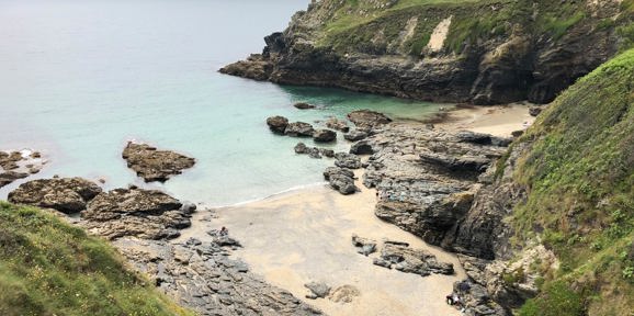 Prussia Cove rocky shoreline and hidden sandy beach with turquoise waters near Praa Sand Holiday Park
