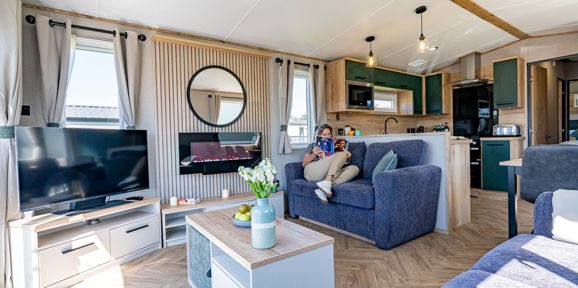 ABI St David, woman reading on the sofa at Praa Sands