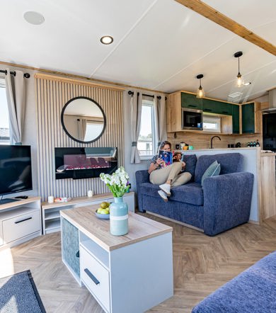 ABI St David, woman reading on the sofa at Praa Sands