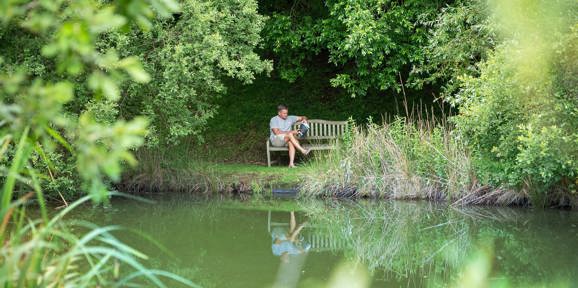Man reading by Dartmoor View pond
