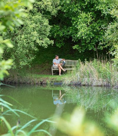Man reading by Dartmoor View pond