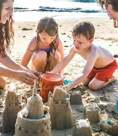 The Warren Local Area Family Playing On The Beach