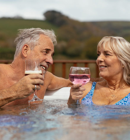 Couple enjoying drinks in holiday home hot tub