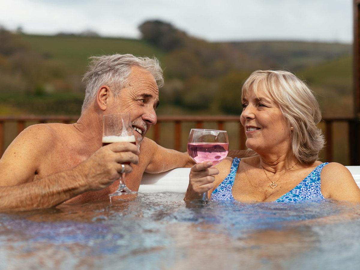 Couple enjoying drinks in holiday home hot tub