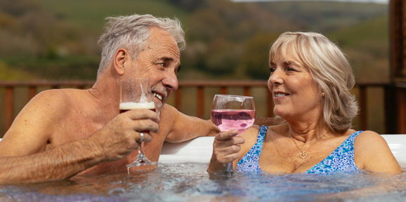 Couple enjoying drinks in holiday home hot tub