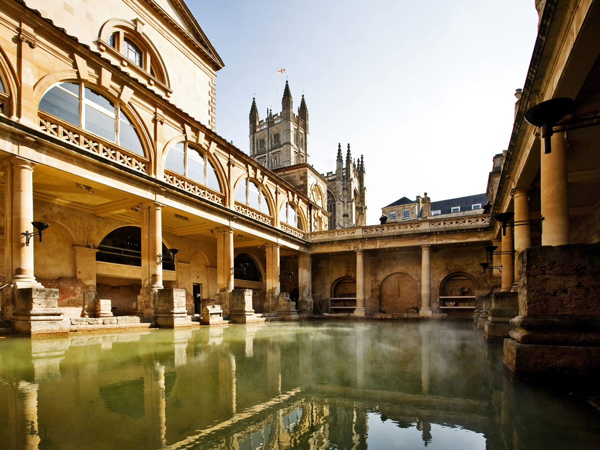 The ancient Roman Baths in Bath, with steaming waters surrounded by classical stone columns, Near Brokerswood Holiday Park.