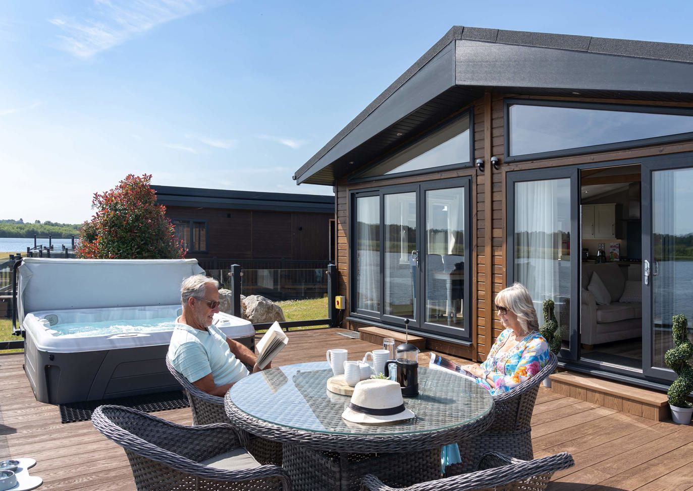 Delamere Couple Sat Outside Relaxing By Lake