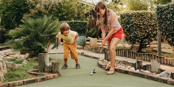 Family playing adventure golf near Devon Hills Holiday Park