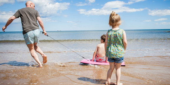 Tal Y Fan Local Area Family Playing At Beach