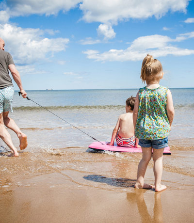 Tal Y Fan Local Area Family Playing At Beach