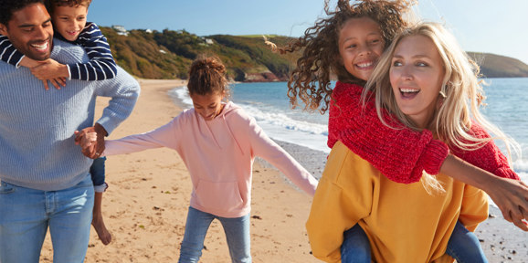 The Warren Local Area Children Piggybacks On Beach