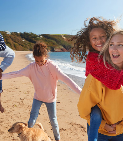 The Warren Local Area Children Piggybacks On Beach