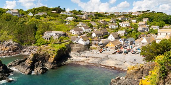 Colourful fishing village of Cadgwith Cove with traditional cottages and rugged cliffs, near Praa Sands Holiday Park.