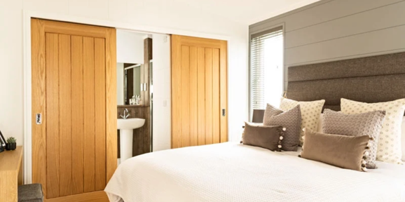 Prestige Dovecote, master bedroom with doors at Brokerswood