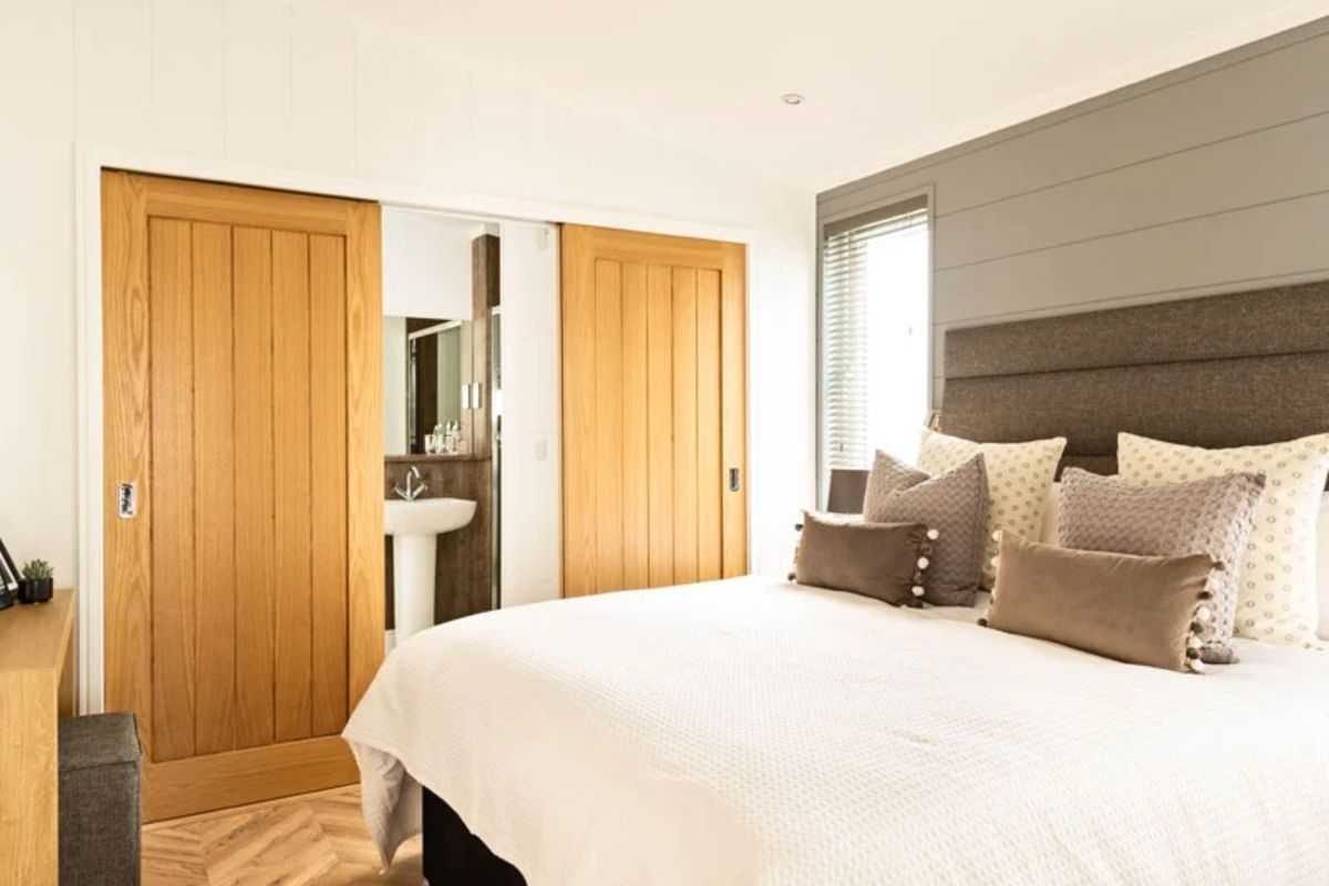 Prestige Dovecote, master bedroom with doors at Brokerswood