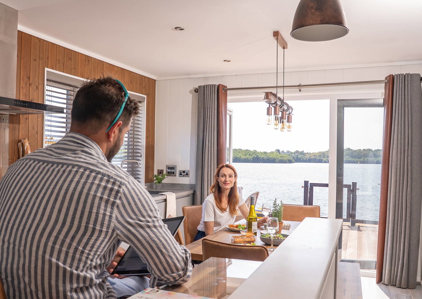 Delamere Couple Talking In Kitchen With Lake View