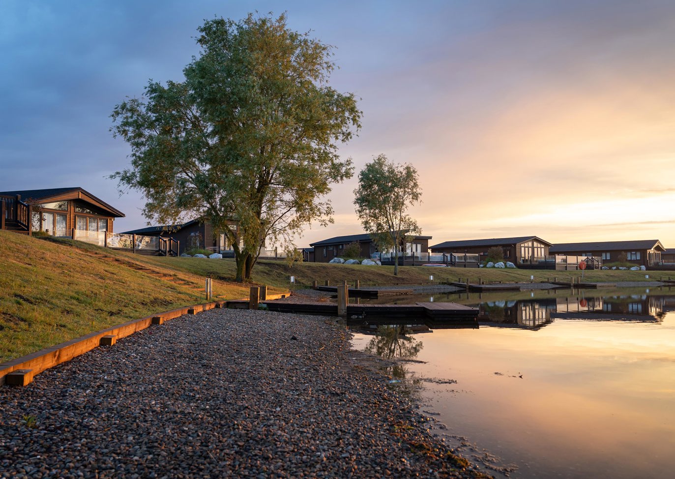 Delamere Overview Lodges Around Lake In Evening Sunshine