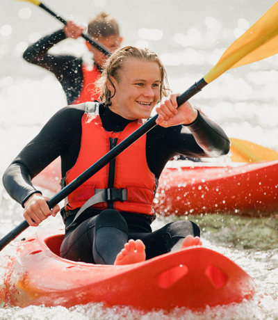 Teenager kayaking in the sea during a coastal adventure near Praasand Holiday Park.