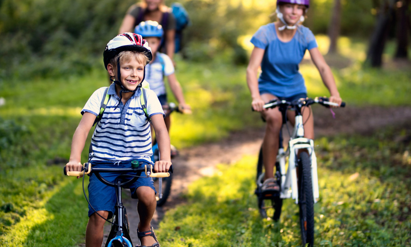 Family Cycling In Woods near Devon Hills Holiday Homes