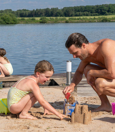 Delamere Family Playing By Lake On Beach