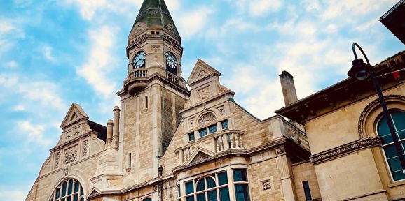 Historic Trowbridge Town Hall with its tall clock tower against a blue sky, Near Brokerswood Holiday Park.