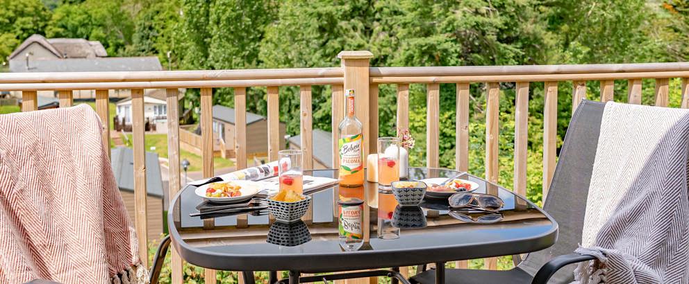 Devon Hills Two Chairs And Drinks Looking Out At View