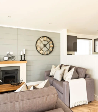 Prestige Dovecote, sofa and fireplace in lounge at Brokerswood