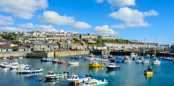 Colourful fishing boats docked in Porthleven Harbour near Praa Sand Holiday Park.