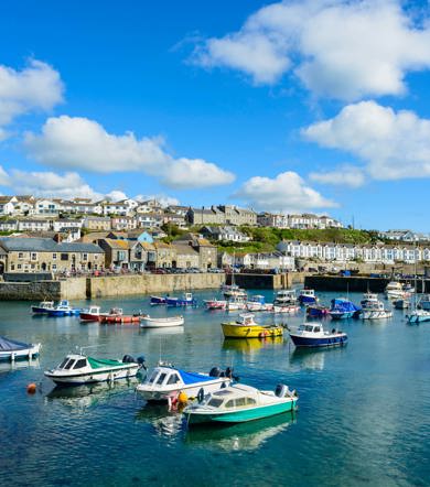 Colourful fishing boats docked in Porthleven Harbour near Praa Sand Holiday Park.