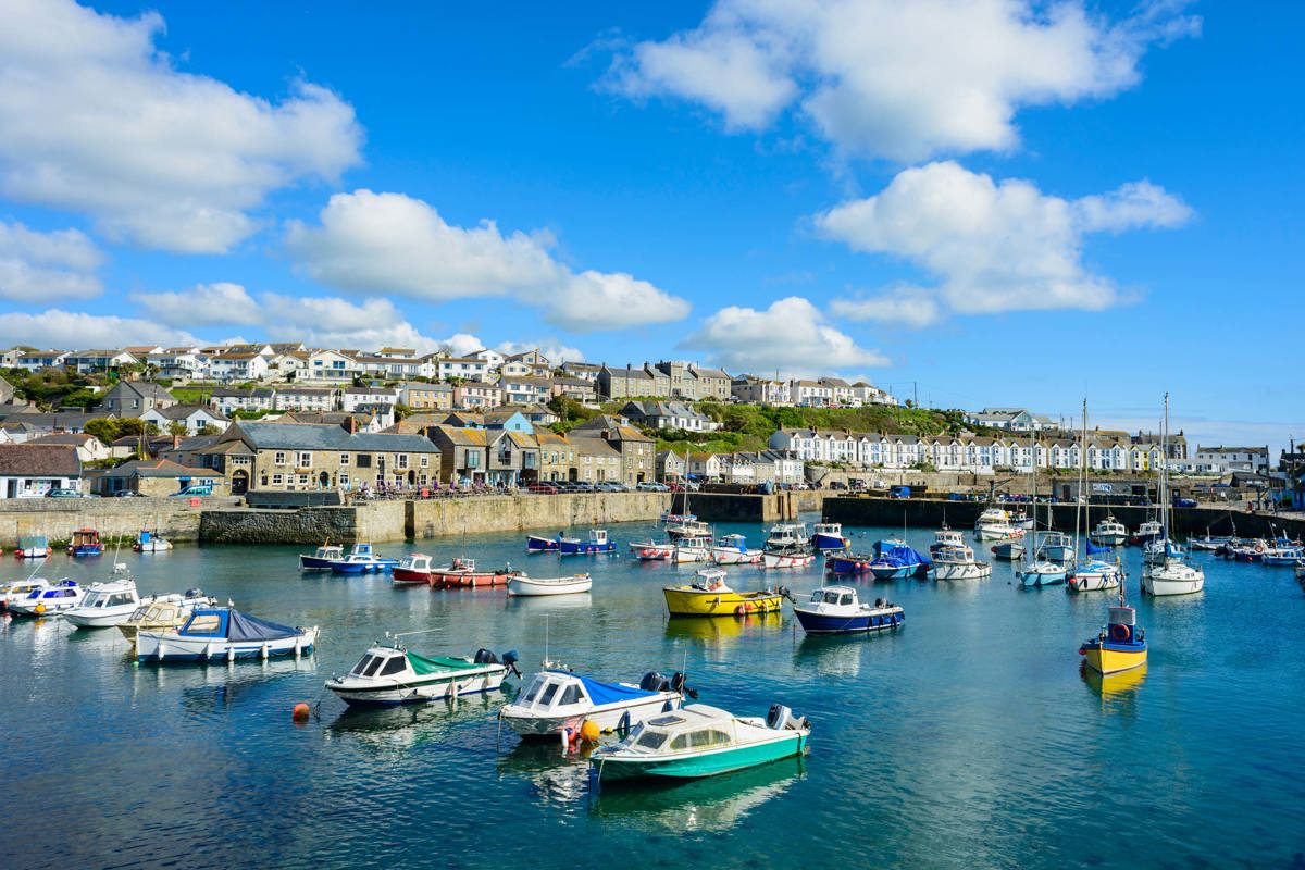 Colourful fishing boats docked in Porthleven Harbour near Praa Sand Holiday Park.