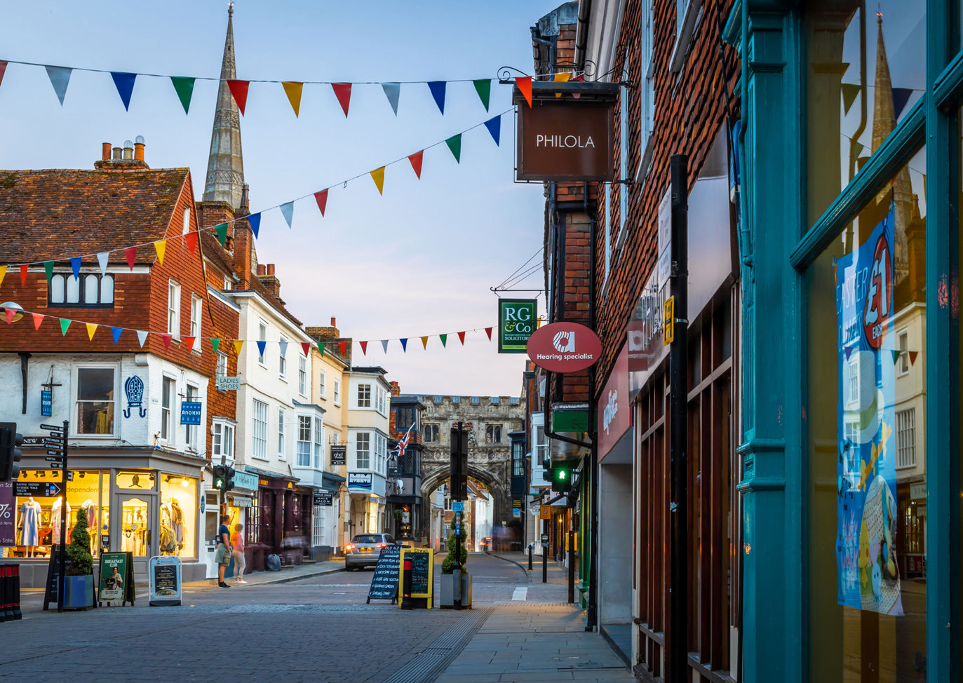 Charming high street with bunting and shops leading towards the historic gate of Salisbury Cathedral, Near Brokerswood Holiday Park.