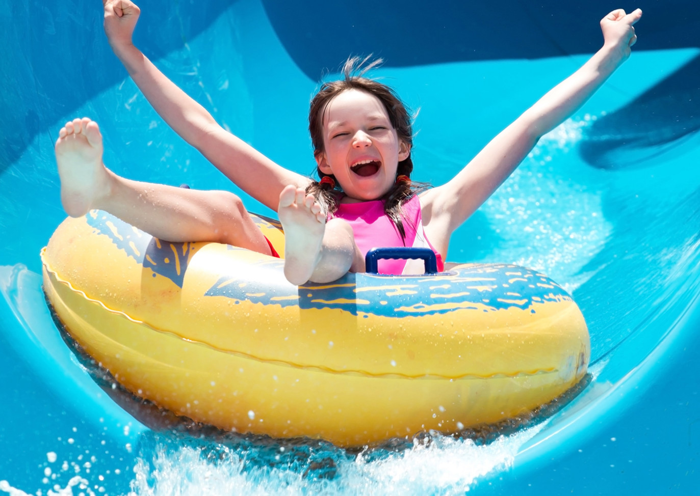 Girl On Waterslide in yellow rubber dingy near Devon Hills Holiday Park