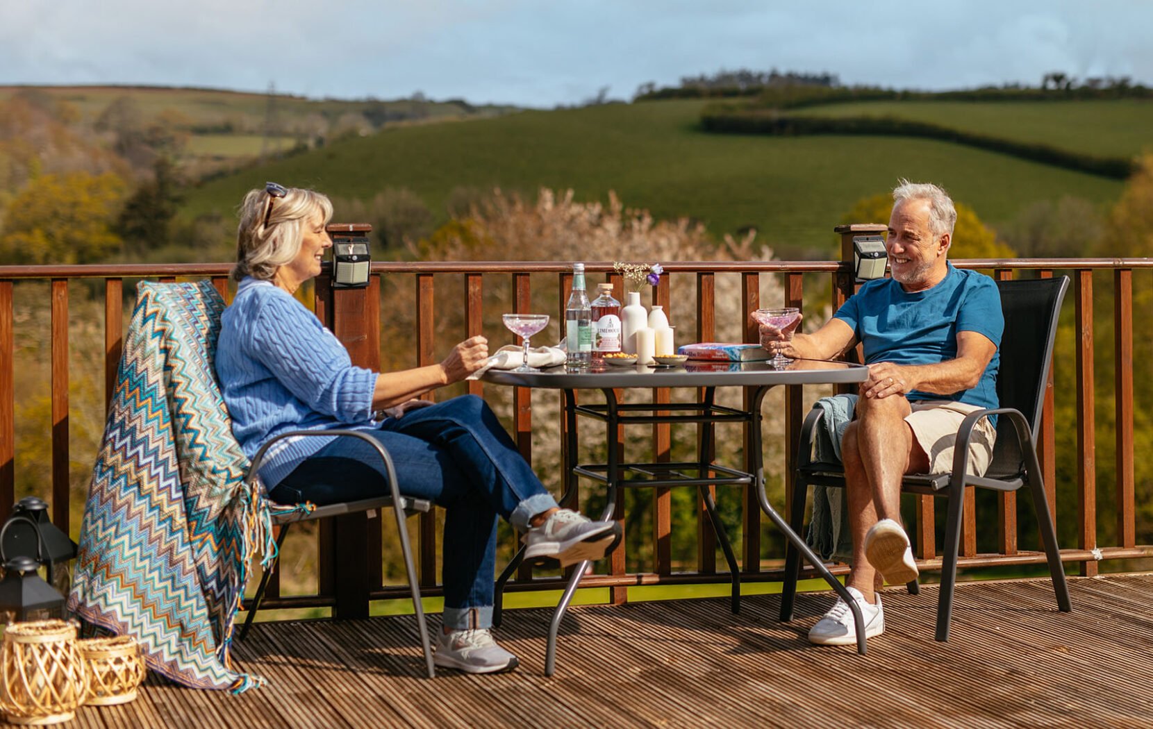 Couple enjoying cocktails out on the deck overlooking the Devon hill