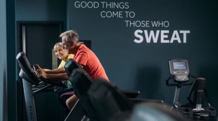 Older couple making the most of the gym area in a modern looking gym