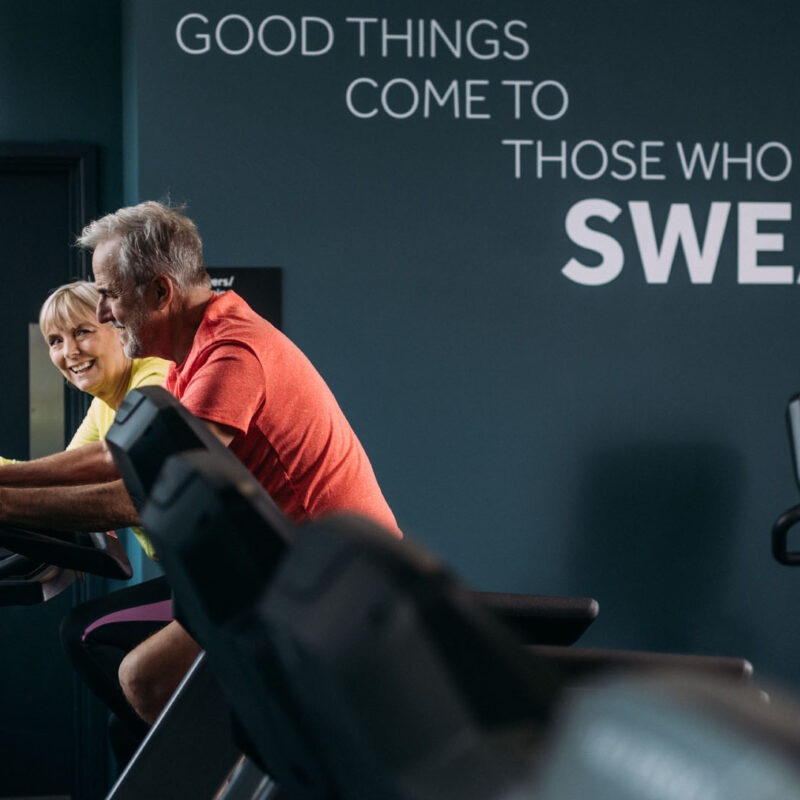 Older couple making the most of the gym area in a modern looking gym