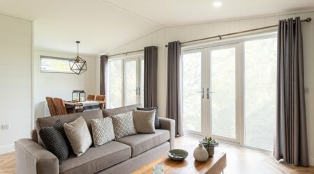 Open plan lounge with a grey sofa, parquet flooring in warm tones