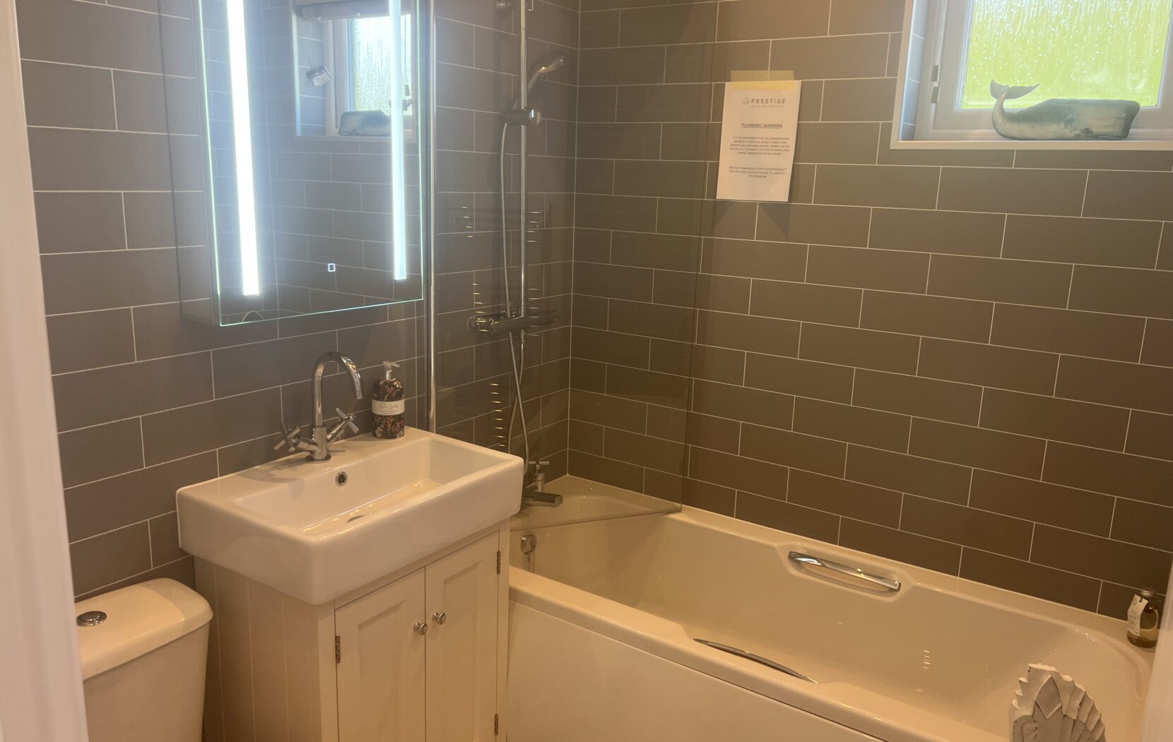 Bathroom with bath and overhead shower, with neautral tones