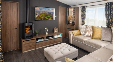 Carnaby Langham lounge area with five seater corner sofa fire place and TV mounted on the wall.